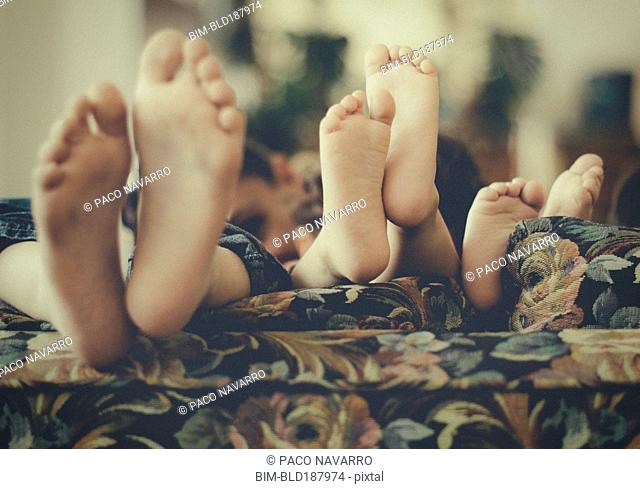 Close up of feet of children on sofa