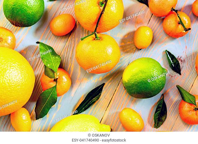 Close-up of various citrus fruits including mandarin orange, lime, lemon and kumquat. Healthy rustic food. Harvest concept