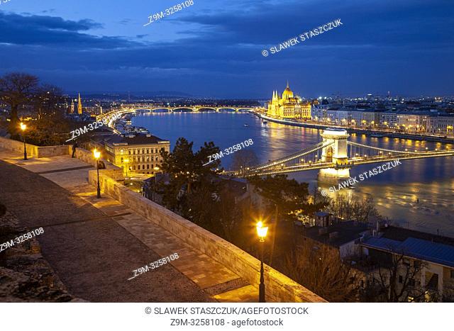 Night falls in Budapest, Hungary. Chain Bridge across the Danube and Parliament building in the distance