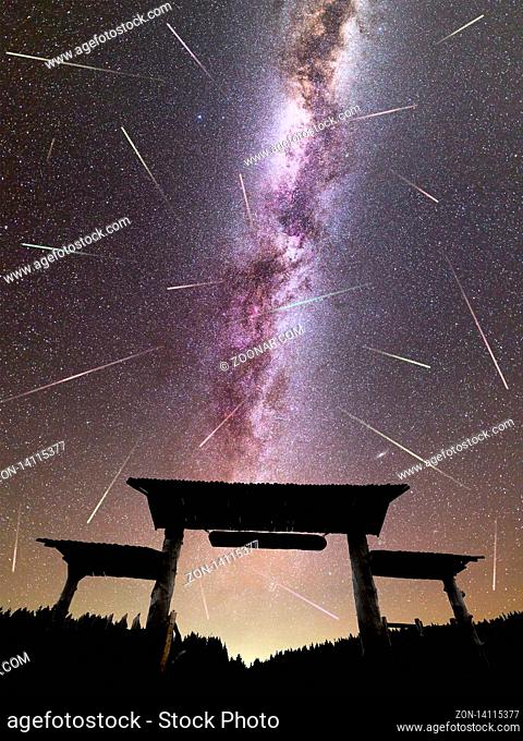 A view of a Meteor Shower and the purple Milky Way with wooden entrance door with a roof and fence silhouette in the foreground
