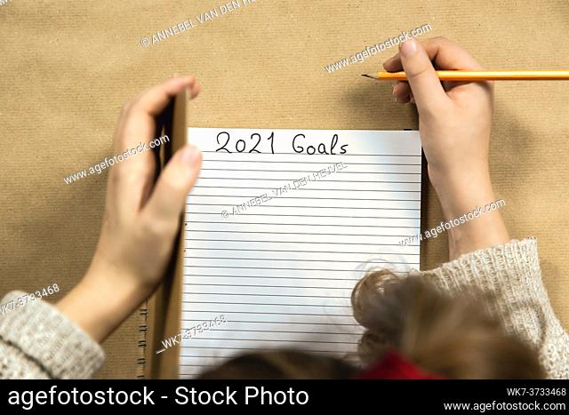 Open Notebook writing 2021 New Year goals Close up on brown background, Business or education motivation, inspiration concept