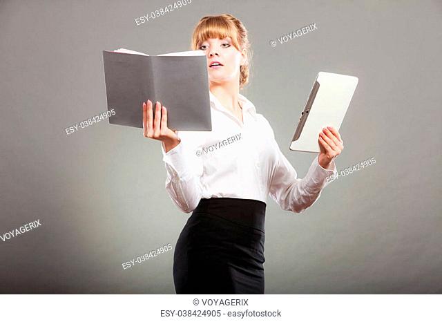 Woman learning with ebook reader and book. Choice between modern educational technology and traditional way method. Girl holding digital tablet pc and textbook