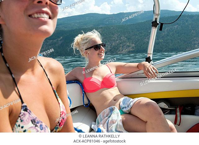 Taylor and Kali relax in bikinis in the hot sun on a boating day in the Okanagan, BC Canada