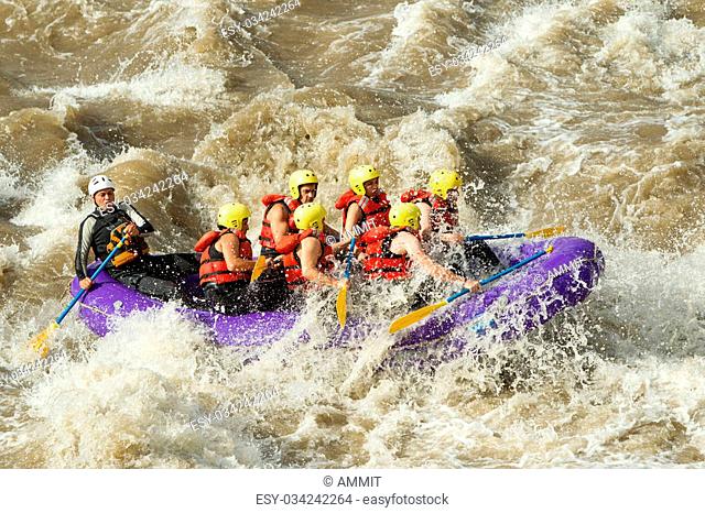 Group Of Mixed Tourist Men And Women With Guided By Professional Pilot On Whitewater River Rafting In Ecuador