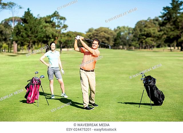 Happy golfer taking shot