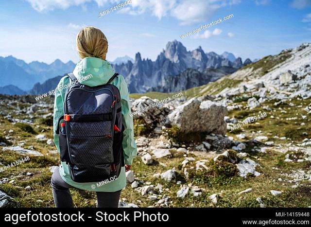 woman hiker with backpack against cadini di misurina mountain group range of italian alps, dolomites, italy, europe