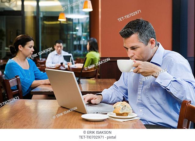 Man working on laptop in restaurant