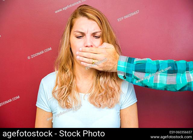 Great concept of male censorship, woman with mouth covered by man's hand