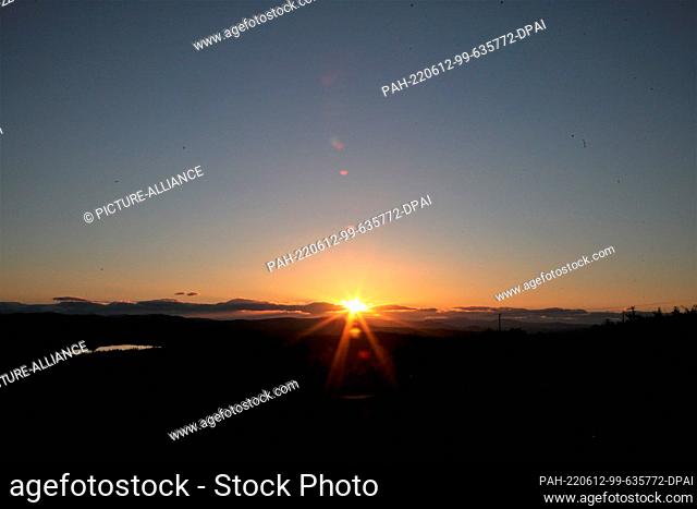 FILED - 08 June 2022, Sweden, Kiruna: The midnight sun can be seen at night over a natural landscape near Kiruna. Around the summer solstice