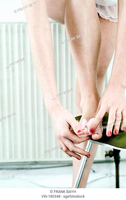 Woman painting her toenails.  - GERMANY, 04/01/2006