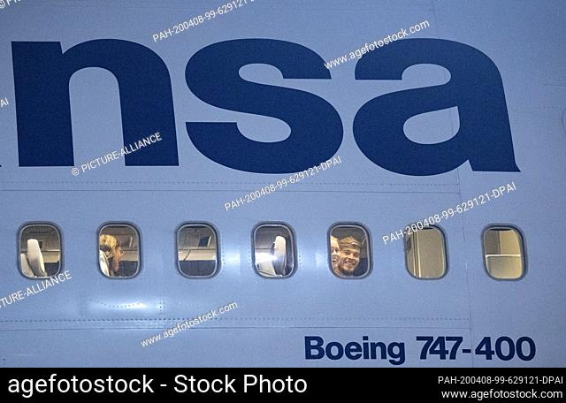 08 April 2020, Hessen, Frankfurt/Main: Passengers wait in the cabin of a Boeing 747 of Lufthansa after landing at Frankfurt Airport to be allowed to leave the...
