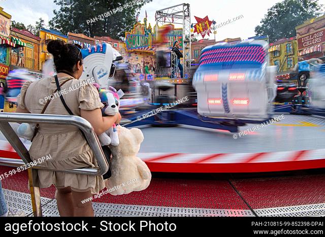 15 August 2021, North Rhine-Westphalia, Neuss: A woman waits at the ""Sound Machine"" ride in the ""Novesia Fun Park"". The largest pop-up funfair in NRW has...