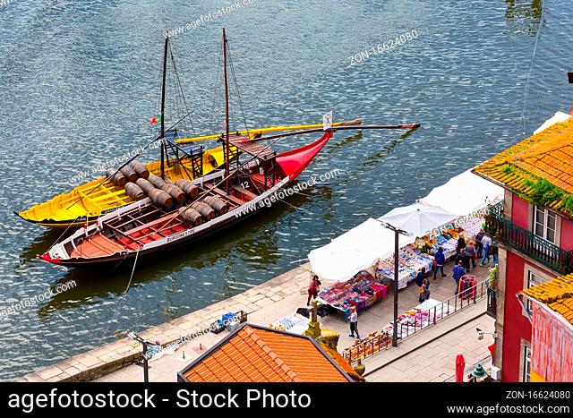 Porto, Portugal - April 1, 2018: Top view od traditional boats with wine barrels at Douro river and market