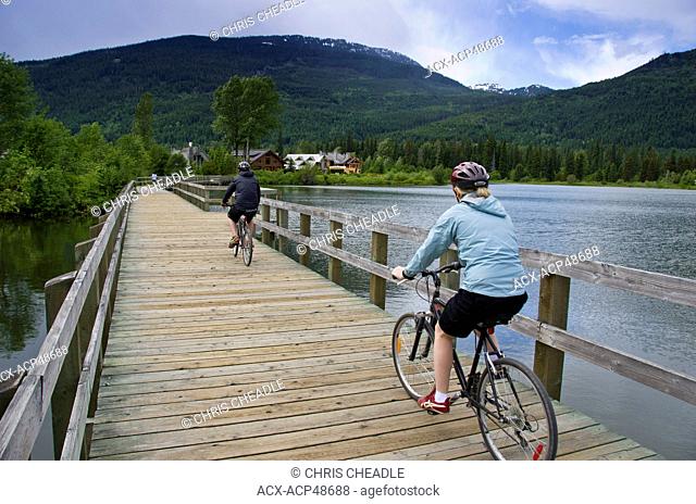 Cyclists on Green Lake boardwalk, Whistler, British Columbia, Canada