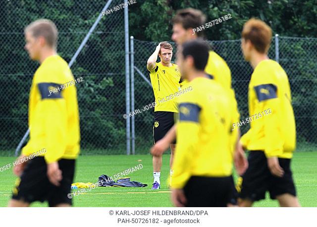 Marco Reus (C) of Borussia Dortmund goes through their warm-up routine during a training session at the team's training camp in Bad Ragaz, Switzerland