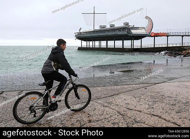RUSSIA, REPUBLIC OF CRIMEA - DECEMBER 10, 2023: A boy rides a bicycle by the Black Sea in the city of Yalta. Sergei Malgavko/TASS