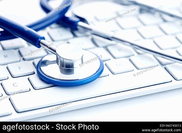 Close up of a Stethoscope on computer keyboard on white desk. Online health care or telemedicine concept. Medical background