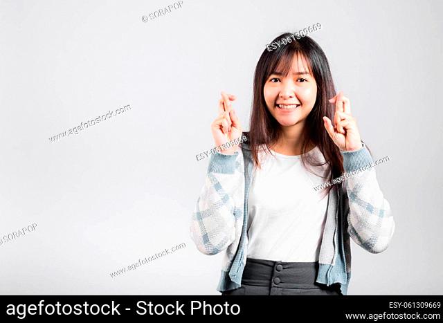 Happy woman have superstition her holding fingers crossed for good luck gesture, Asian beautiful young female smiling superstition