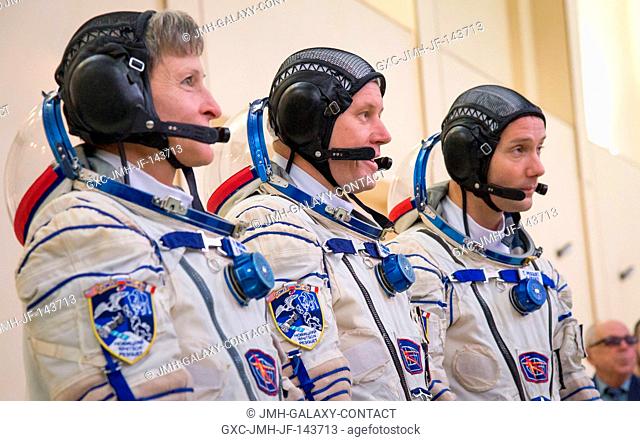 Expedition 50 crew members NASA astronaut Peggy Whitson, left, Russian cosmonaut Oleg Novitskiy of Roscosmos, center, and ESA astronaut Thomas Pesquet report to...