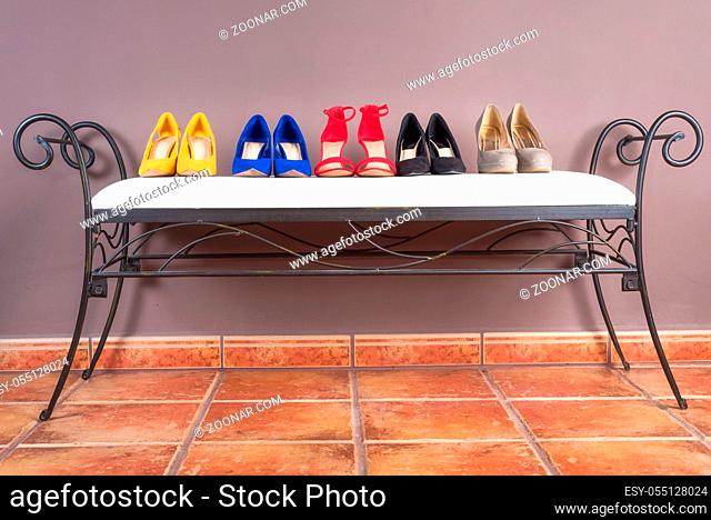 Collection of woman high heel shoes, on white sofa