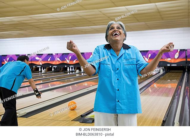 African woman cheering in bowling alley