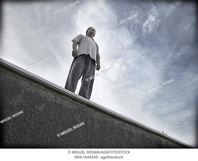 Challenging single man standing on a ledge