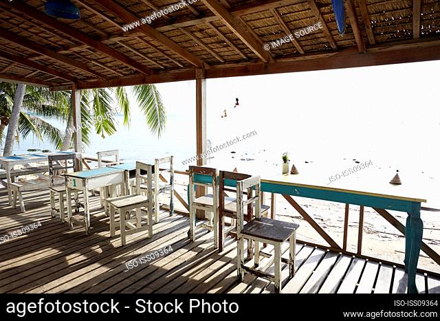Chairs and tables on porch by beach