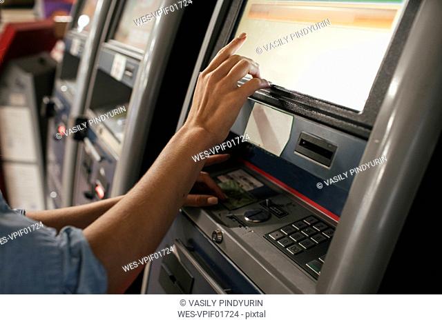 Young female traveller buying ticket from automated machine at station