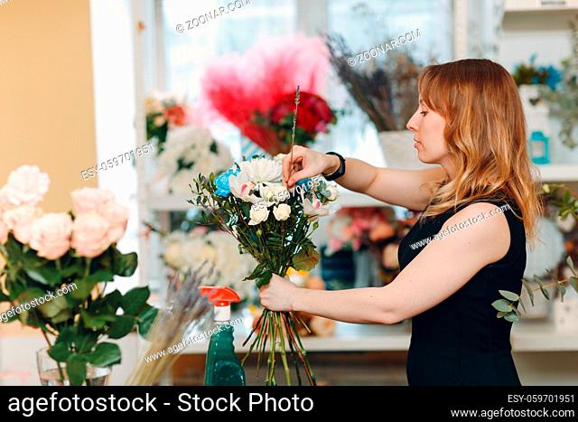 Florist woman make bouquet in flower boutique