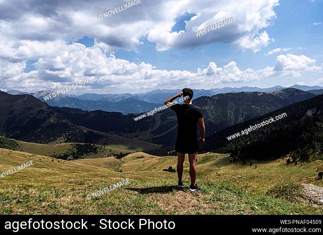 Hiker looking at mountains on sunny day