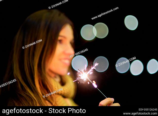 woman having fun with sparkler in her hands