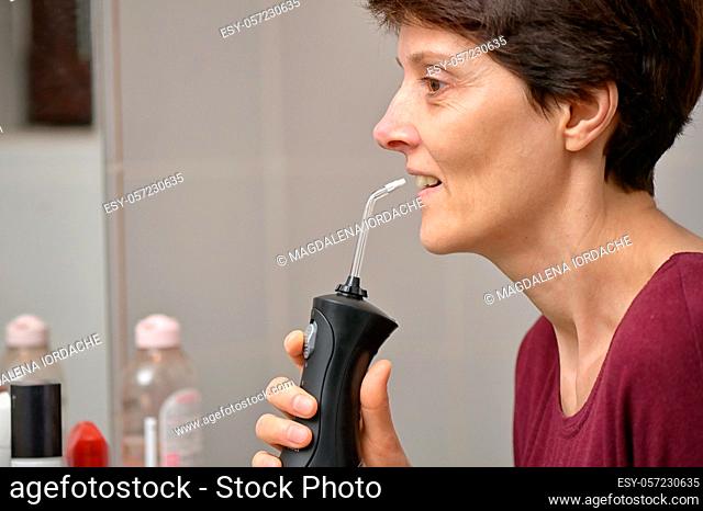 Portrait Of A Young Womanand and Professional Oral Irrigator or Flosser