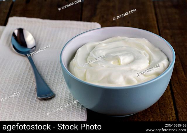 Natural creamy Greek yoghurt on wooden table