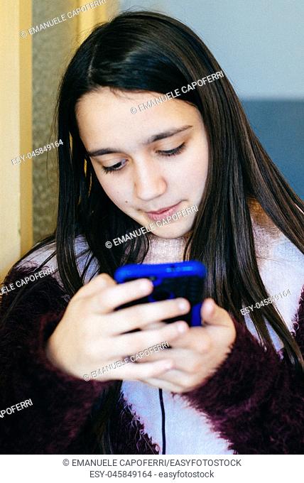 girl looks at the smartphone-portrait of absorbed little girl in the phone screen