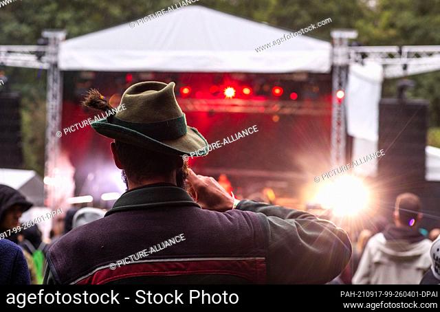 17 September 2021, Mecklenburg-Western Pomerania, Jamel: A forester drinks a beer at the concert ""Jamel rocks the forester"" in front of the stage in the small...