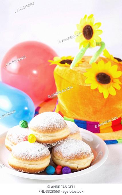Doughnuts, colourful hat and toy balloons, high angle view