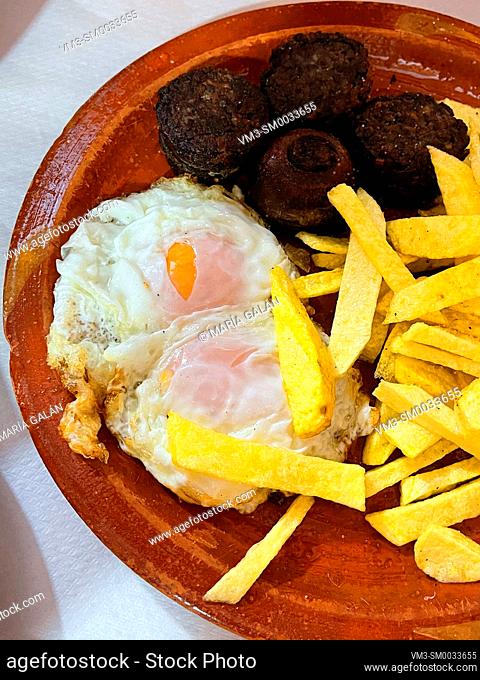 Fried eggs with chips and black pudding. Spain