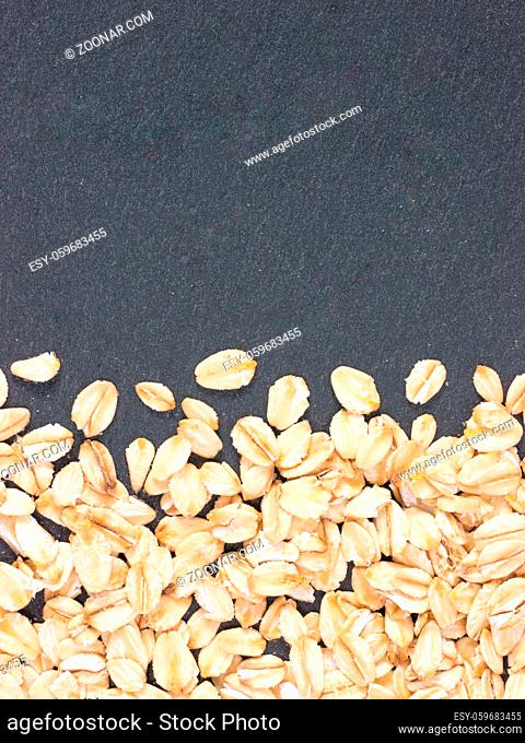raw oatmeal on gray background with copy space. Isolated one edge. Top view or flat lay