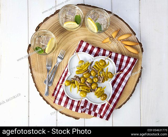 olive and anchovy flag with lemonade in wood plate and white background