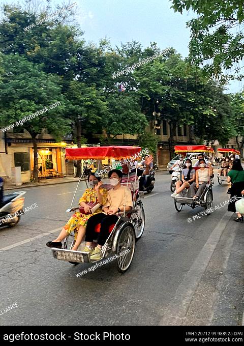 PRODUCTION - 19 June 2022, Vietnam, Hanoi: Bicycle rickshaws drive through the Old Quarter of Hanoi. While foreign tourists are still rare