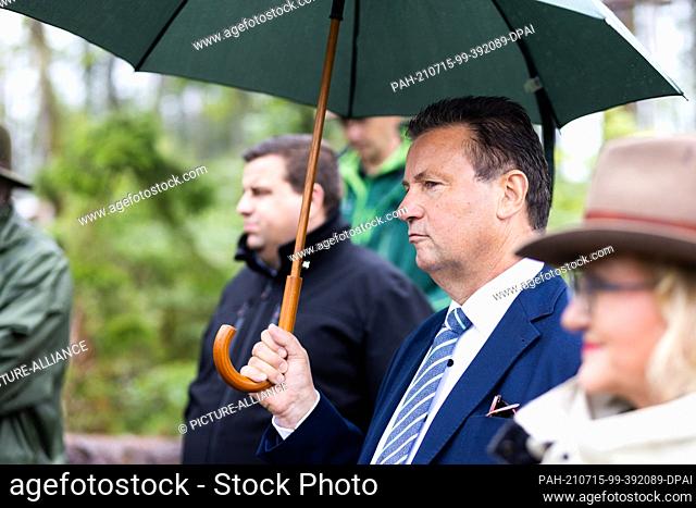15 July 2021, Baden-Wuerttemberg, Albbruck: State Minister Peter Hauk (CDU, with umbrella) stands in the forest during an inspection