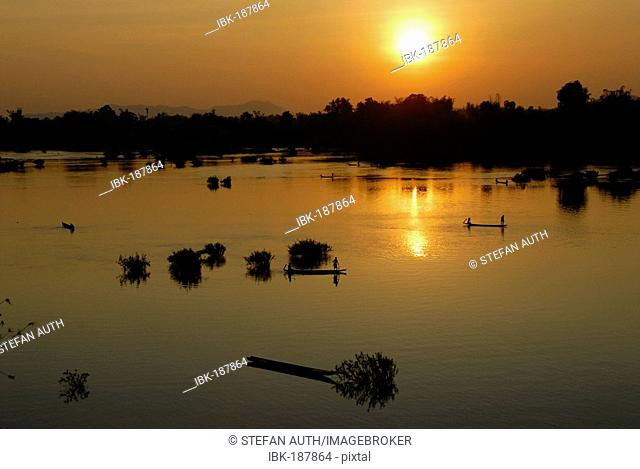Sunset fishermen in boats on the Mekong River Muang Khong Si Phan Don Laos