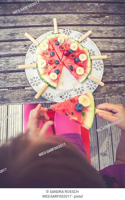 Girl eating watermelon pizza