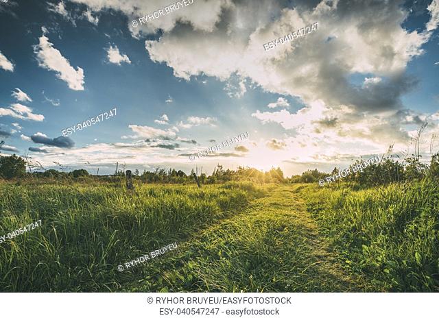 Beautiful Sunset, Sunrise Over Rural Meadow. Dramatic Sky And Country Road Path Way Lane. Countryside Landscape At Sunset Dawn Sunrise. Skyline