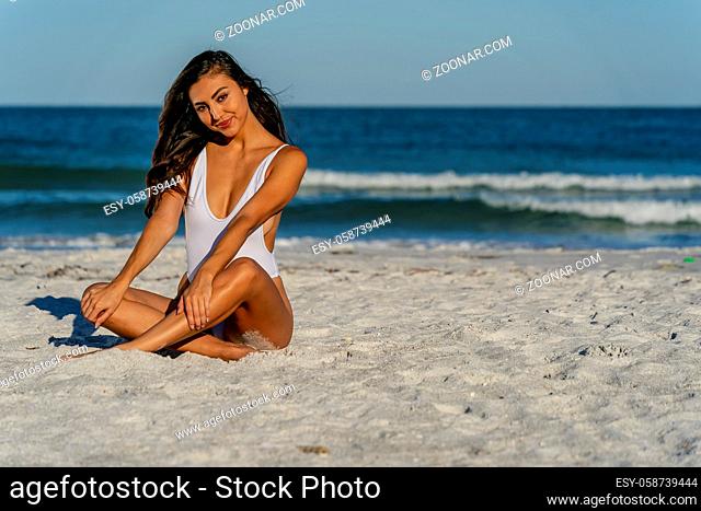 A beautiful mixed race bikini model enjoys the weather outdoors on the beach