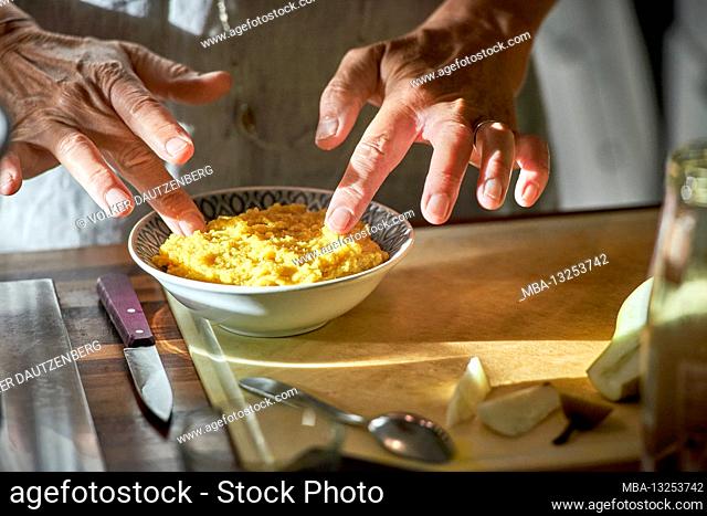 Woman's hands prepare polenta in a bowl