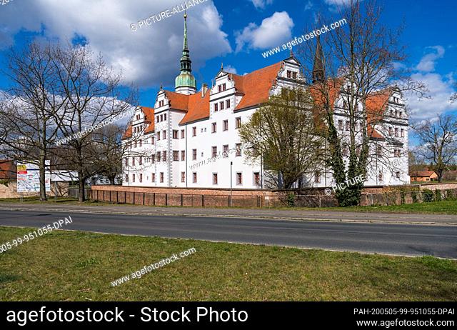 14 April 2020, Brandenburg, Doberlug-Kirchhain: The city castle behind the castle wall and the main street. The Renaissance castle has seen several owners and...