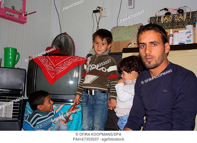 Mohammed Ramadan (R) and his three children aged 5, 3 and 2 respectively pictured in a accommodation container in the Zaatari refugee camp located close to the...