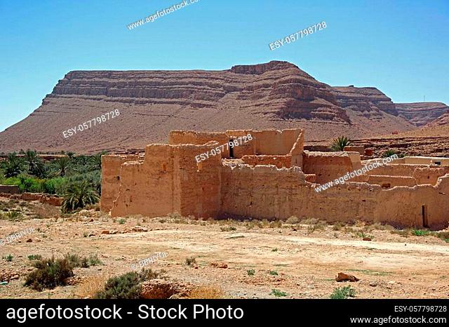Ancient Kasbah found in Morocco's desertic countryside with surrounding desert and palm trees