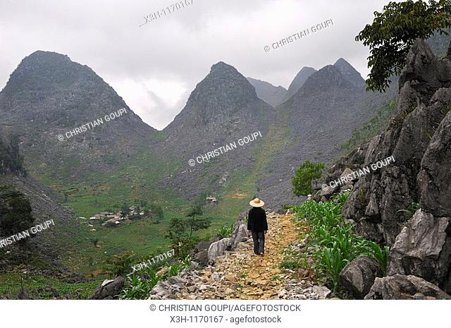 man walking along a mountain path, around Dong Van, vietnam, southeast asia